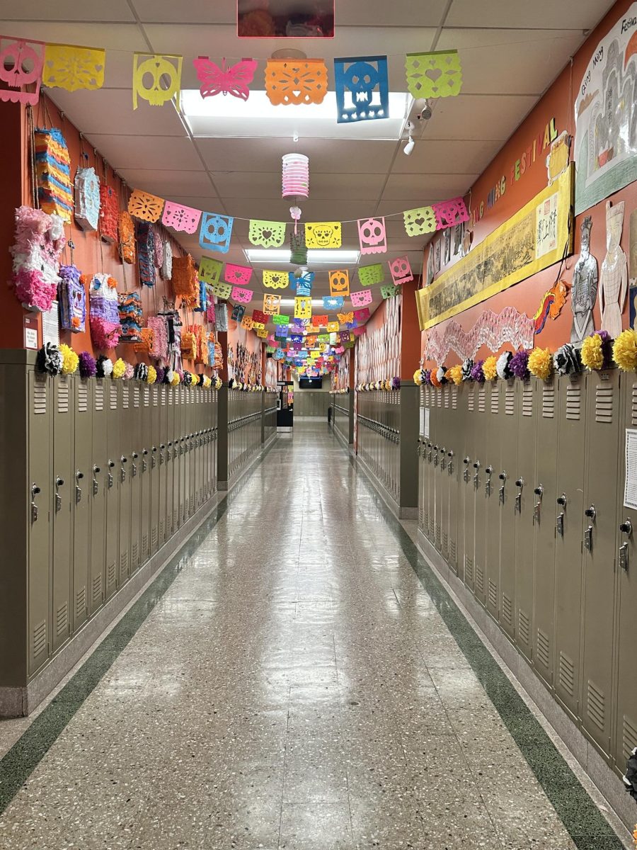 3rd floor language hallway decorated with papel picado, paper flowers and skulls for the Day of the Dead.