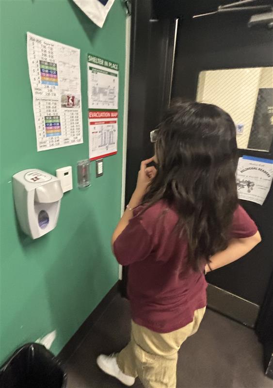 Senior Berenise Velero checks the schedule for early dismissal.  