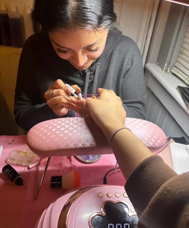 Senior Kimberly Arellano does her client's nails.  