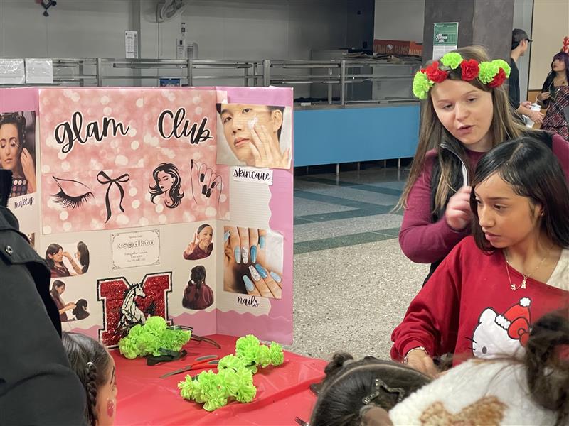 Alexandra Platek, Glam Club sponsor, making flower crowns with students.