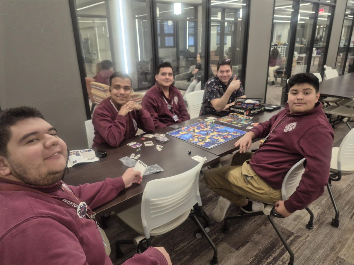 Nathaniel Moore, Gerardo Ayala, Ignacio Meraz, Adrian Montoya, and Adrian Ramirez-Martinez play a board game.