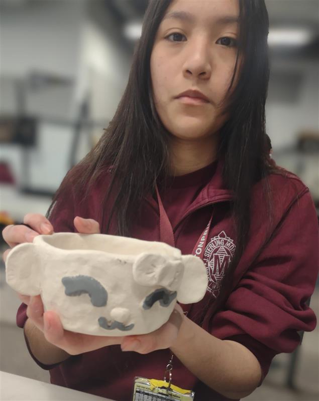 Crisol Moreno shows off her monkey teacup sculpture, proud of her progress as she continues working in class. "I'm looking forward to spending time with my family and going to church more often this spring break," Moreno said.