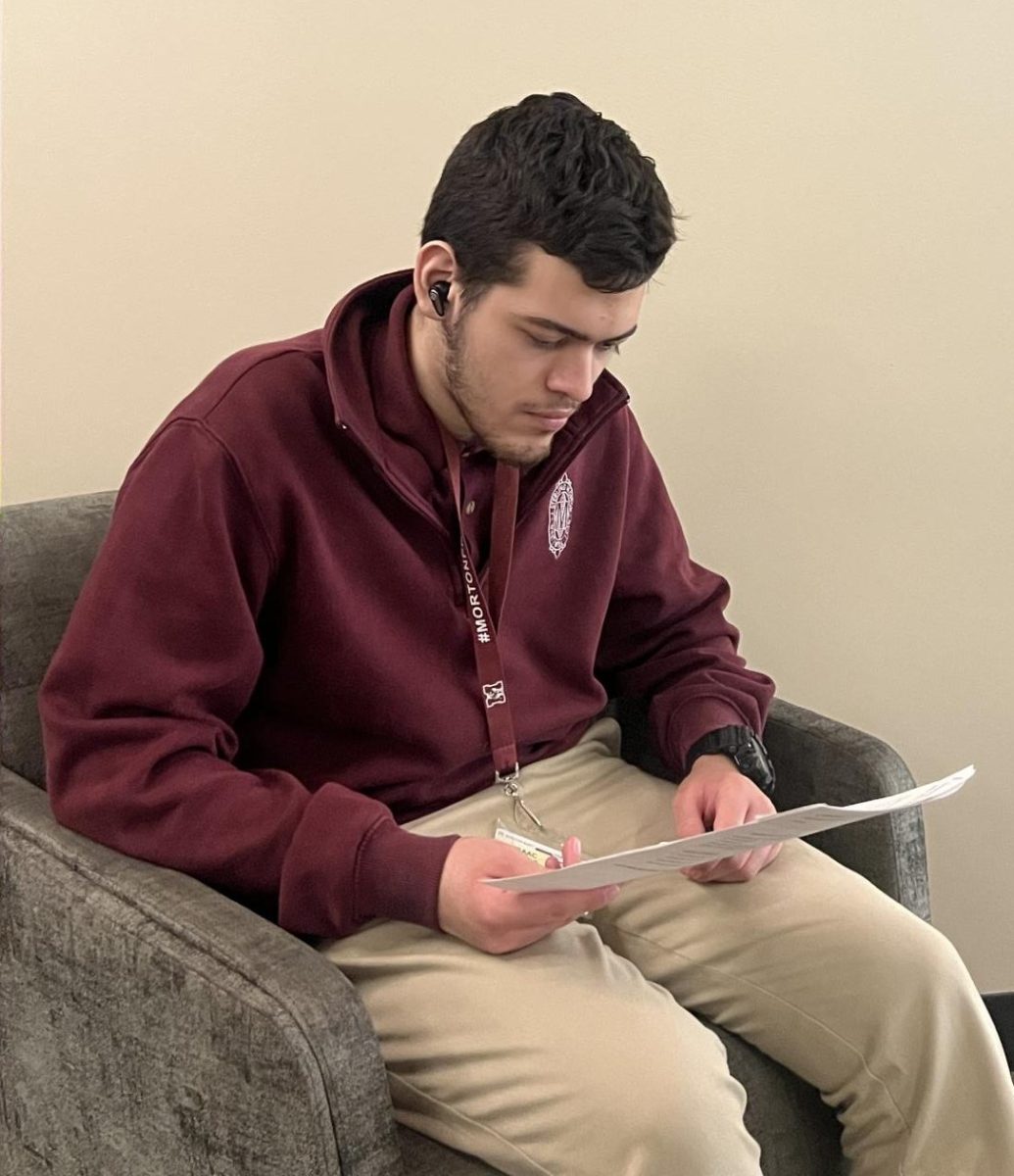 Senior student, Isaac Alanis, studies while listening to music with his ear buds.