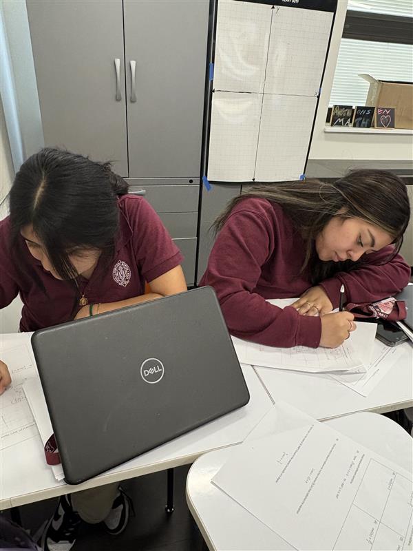 Seniors Joanna Martinez and Juliana Salcedo work separately on their math homework.