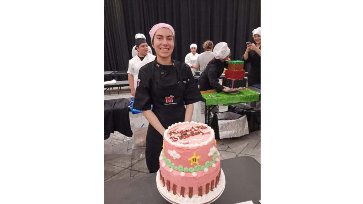 Areli Laura poses with her award-winning cake after competing in a cake decorating competition, where she showcased her creativity and skills developed all throughout her three years being in culinary. 